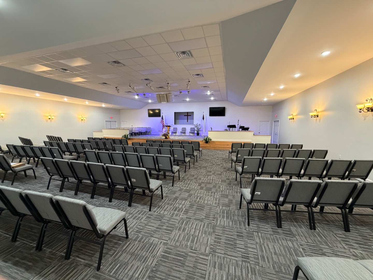 Bluewater Baptist Church sanctuary with seating, stage, and cross